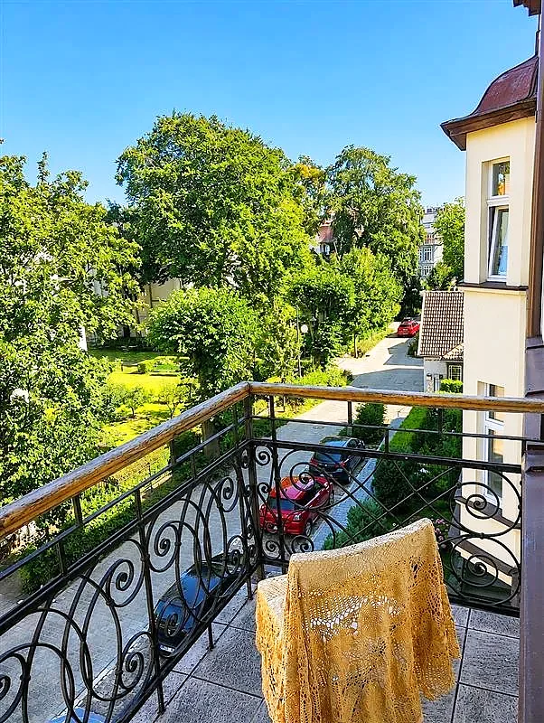Balkon z ozdobną balustradą i widokiem na zieleń; mieszkanie przy ul. Parkowej w Sopocie